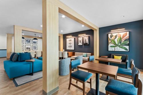 a living room with a blue couch and a table at Everhome Suites Ocala I-75 North in Ocala