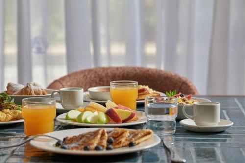 a table with plates of food and glasses of orange juice at Atlantica Oasis Hotel in Limassol