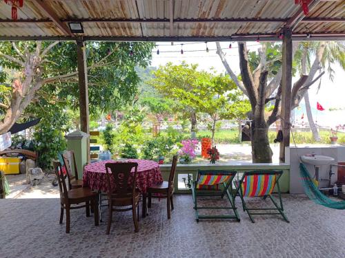 a table and chairs with a table and some trees at Nhi Lo Home Stay in Tân Hiệp