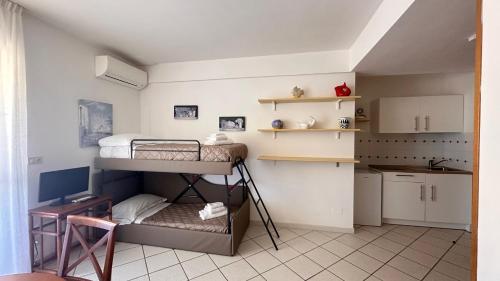 a small room with two bunk beds and a kitchen at Hotel Baia di Talamone in Talamone