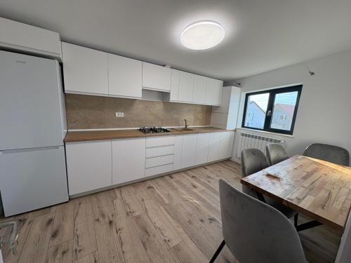 eine Küche mit weißen Schränken und einem Holztisch in der Unterkunft Casa Agigea in Agigea