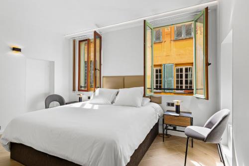 une chambre avec un grand lit et deux fenêtres dans l'établissement Saint-Augustin - Nice Old Town, à Nice