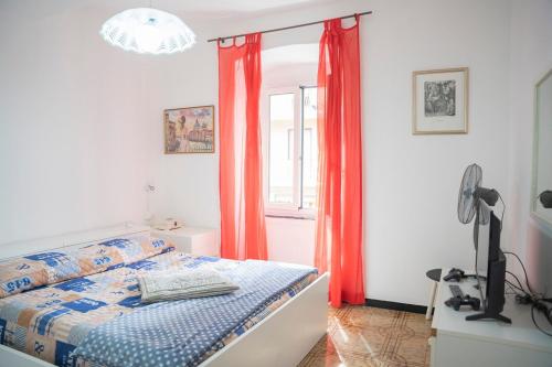 a bedroom with a bed with orange curtains and a window at 008B - Casa RIVA Vista Mare di fronte alla Spiaggia e Mare a Riva Trigoso in Riva Trigoso