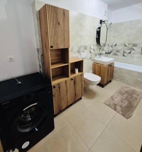 a bathroom with a washer and a toilet and a sink at Milan Luxury Apartaments X in Târgu-Mureş