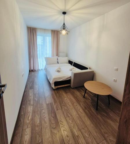 a bedroom with a bed and a table in it at Milan Luxury Apartaments X in Târgu-Mureş