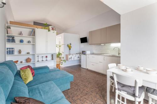 a living room with a blue couch and a kitchen at Casa Rosi in Frontera