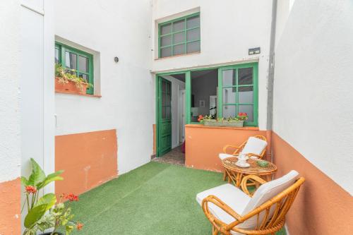 a balcony with chairs and a table and a green door at Casa Rosi in Frontera