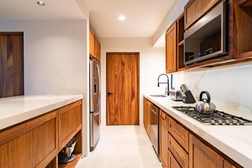 a kitchen with wooden cabinets and stainless steel appliances at 3061 - Amanecer B2 in Tangolunda