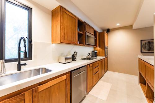 a kitchen with wooden cabinets and a sink at 3061 - Amanecer B2 in Tangolunda