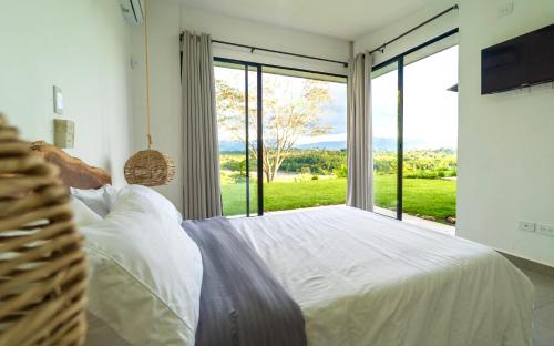a bedroom with a large white bed with a large window at Modern Villa Surrounded by Nature with Pool and Stunning View in La Tebaida