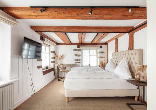 a bedroom with a white bed and a television at Seehaus Allensbach - Riviera Suite in Allensbach