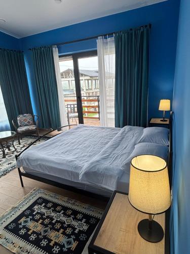 a bedroom with a bed with blue walls and a window at Mountain View in Stepantsminda