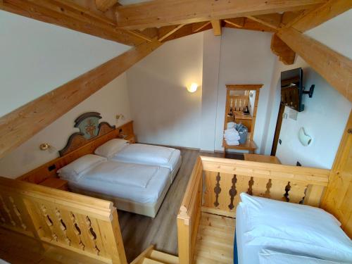 a bedroom with two beds in a attic at Hotel Valacia in Pozza di Fassa