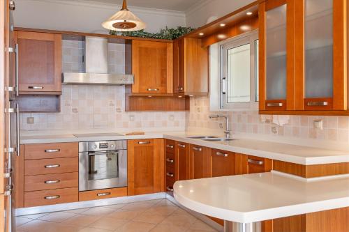 a kitchen with wooden cabinets and a white counter top at Sunset Elysian in Argostoli