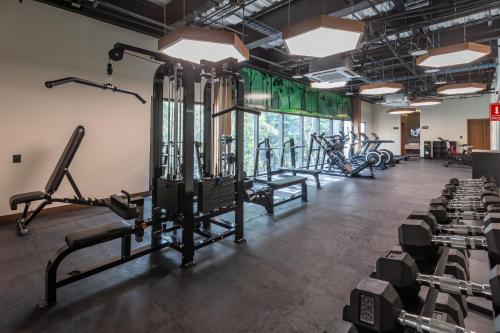 a gym with rows of treadmills and machines at Hotel Mundo Maya Tulum Aeropuerto in Tulum