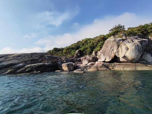 a view from the water of a rocky shore at Nhi Lo Home Stay in Tân Hiệp