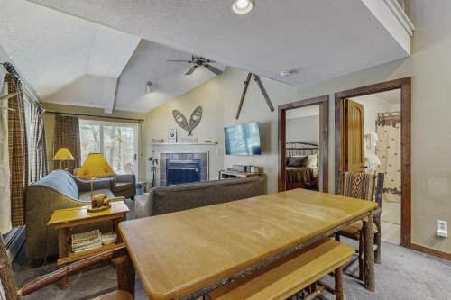 a living room with a table and a couch at The Woods - Village-11 in Killington