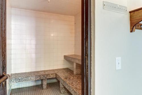 a walk in shower with stone steps in a room at The Woods - Village-11 in Killington