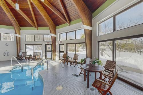 a home with a swimming pool and a table and chairs at The Woods - Village-11 in Killington