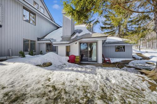 a house with snow in front of it at The Woods - Village-11 in Killington