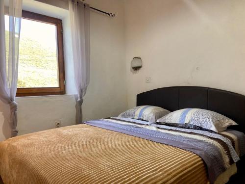 a bed with two pillows and a window in a bedroom at Stone & Sea house in Valdanos