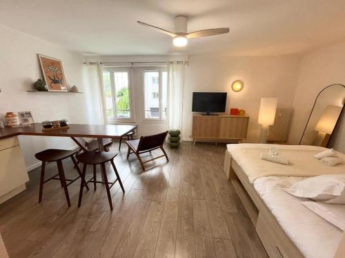 une chambre avec un lit, une table et des chaises dans l'établissement Studio 18 - Parking & proche lac, à Annecy