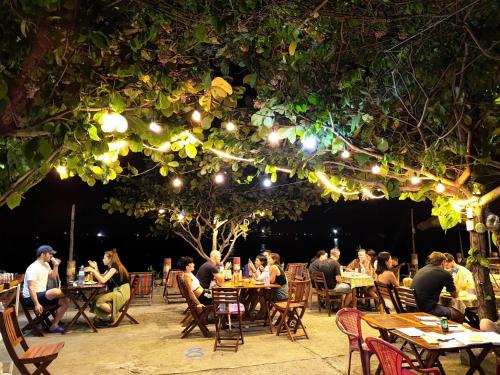 a group of people sitting at tables in a restaurant at Nhi Lo Home Stay in Tân Hiệp