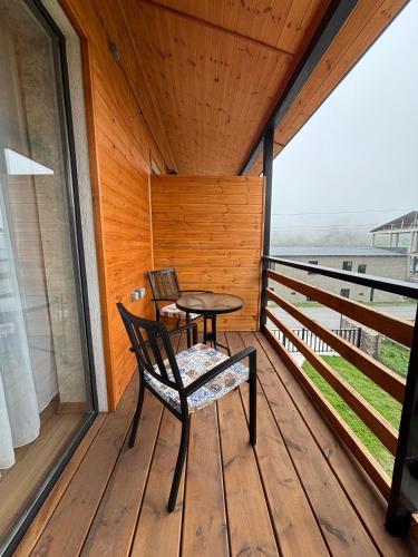 a patio with a table and a chair on a deck at Mountain View in Stepantsminda