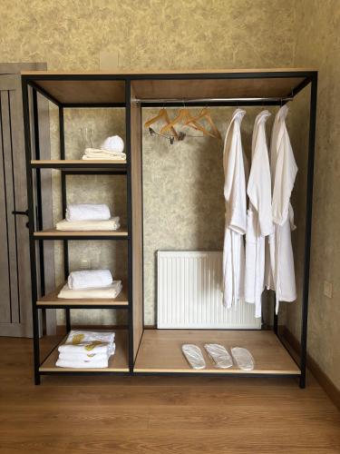 a wardrobe with white clothes and white shoes at Mountain View in Stepantsminda