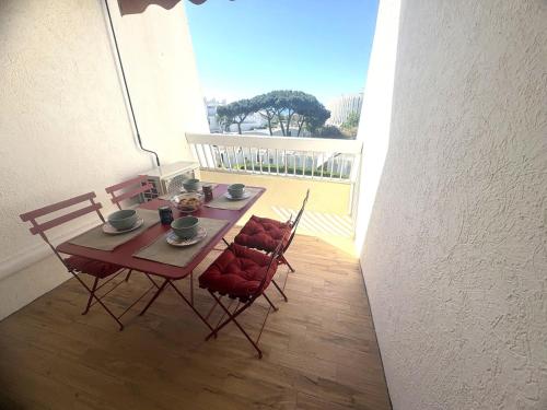 une table et des chaises assises sur un balcon dans l'établissement Couchant Cosy studio, terrasse couverte face à la mer, clim, parking, wifi, à La Grande Motte