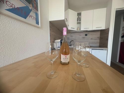 une bouteille de vin et deux verres à vin sur une table dans l'établissement Couchant Cosy studio, terrasse couverte face à la mer, clim, parking, wifi, à La Grande Motte