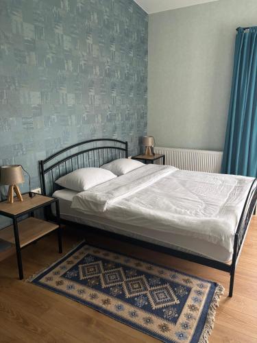 a bedroom with a bed and two tables and a rug at Mountain View in Stepantsminda