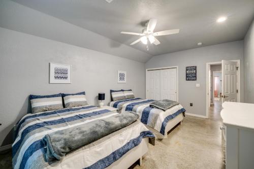 a bedroom with two beds and a ceiling fan at Modern Retreat with Gas Grill - Walk to Lake Texoma! in Kingston