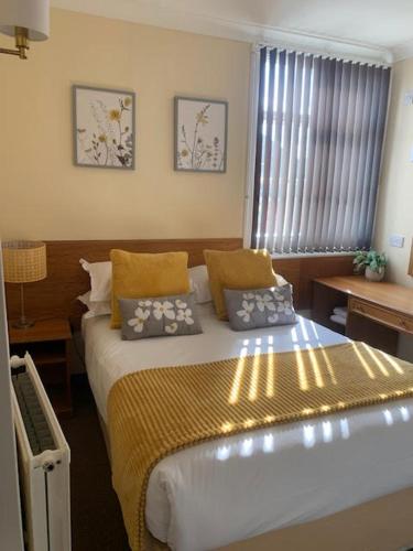 a bedroom with a bed with two pillows on it at The Dickens Bar & Inn in Scarborough