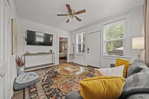 a living room with a couch and a tv at Cedar Blossom Bungalow is a cozy getaway with a 5 minute walk to downtown! in Hot Springs