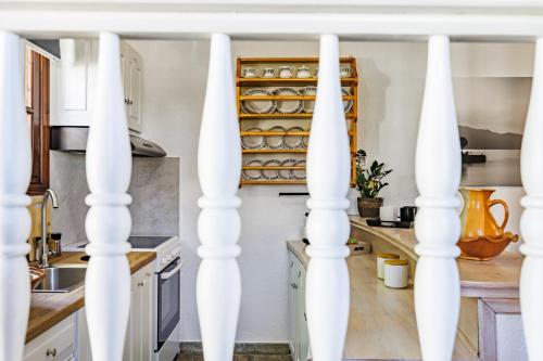 a kitchen with white columns in a kitchen with white cabinets at Efcharis house Skopelos in Neo Klima