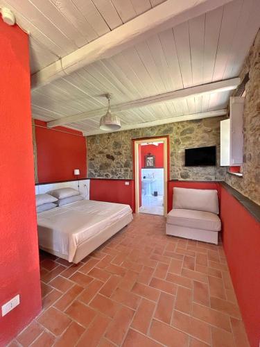 a bedroom with two beds and a red wall at Casa Valle Verde in Brugnato