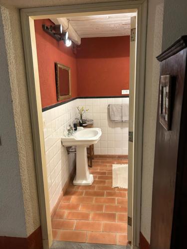 a bathroom with a white sink and a red wall at Casa Valle Verde in Brugnato