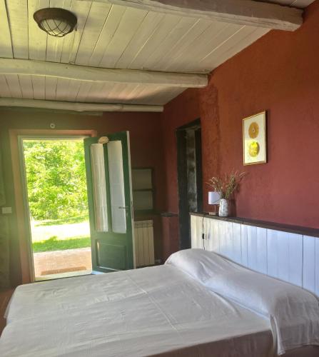 a bedroom with a bed and a green door at Casa Valle Verde in Brugnato