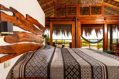 a bedroom with a wooden bed in a room with windows at ALAS Y ARENA in Vichayito