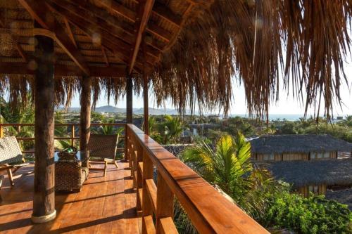 a wooden deck with chairs and a view of the ocean at ALAS Y ARENA in Vichayito