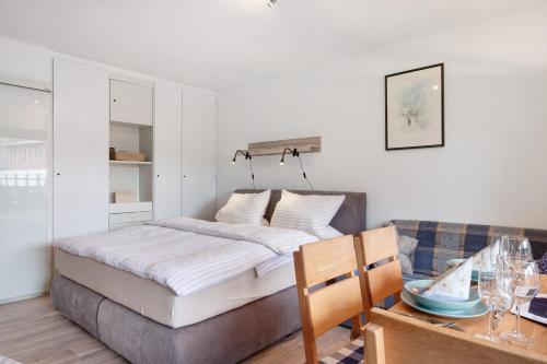 a bedroom with a bed and a couch at Schwarzwaldliebe mit Pool, Sauna in Schonwald im Schwarzwald