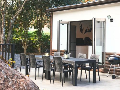 a black dining table and chairs on a patio at Little Deer by SANA in Tateyama