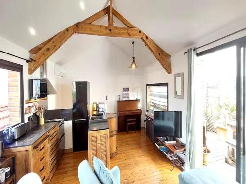 une pièce avec une cuisine et un salon dans l'établissement Charmante maison-chalet, vélos et jacuzzi, à Arcachon