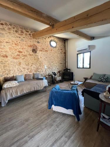 - un salon avec deux canapés et un mur en briques dans l'établissement La Bastide des Crinieres Argentees, à La Celle-sous-Gouzon