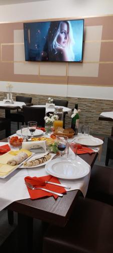 a table with plates of food and a television at Hotel Polonia - Frankfurt/Oder in Frankfurt/Oder