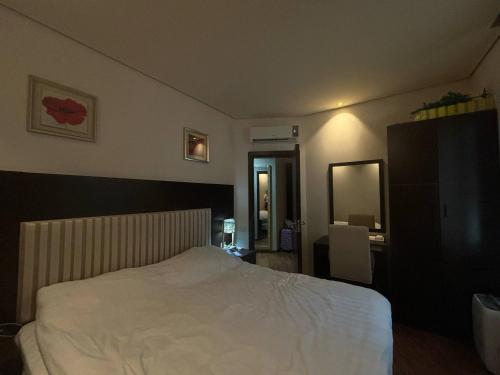 een slaapkamer met een wit bed en een spiegel bij Dreamland oasis in Chakvi