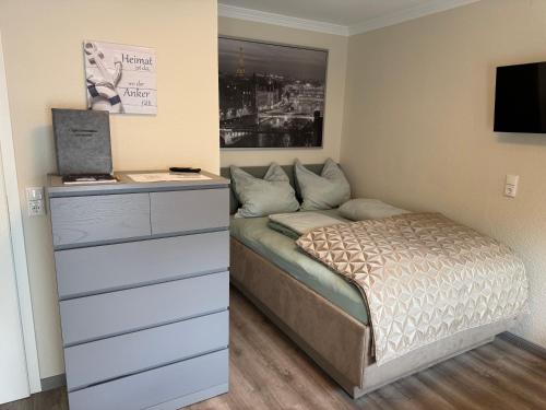 a small bedroom with a bed and a dresser at Apartment Relax in Trittau