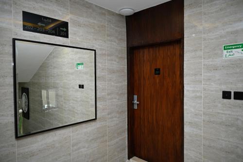 a hallway with a mirror and a wooden door at شقق لافيدا الفندقية in Riyadh