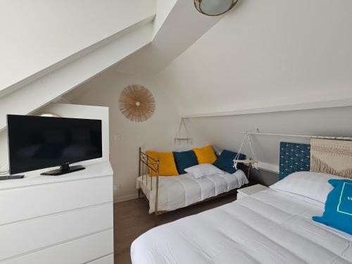 - un salon avec 2 lits et une télévision à écran plat dans l'établissement Le Domicile adoré chez Béa, à Villers-sur-Mer